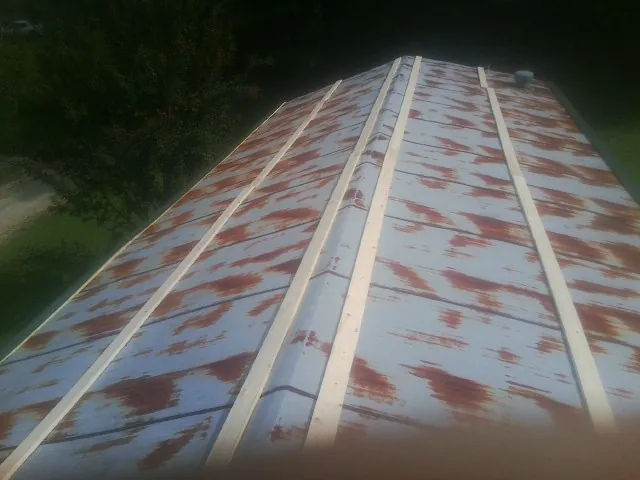 Rusted metal roof panels with new wood purlins before replacement in Salley