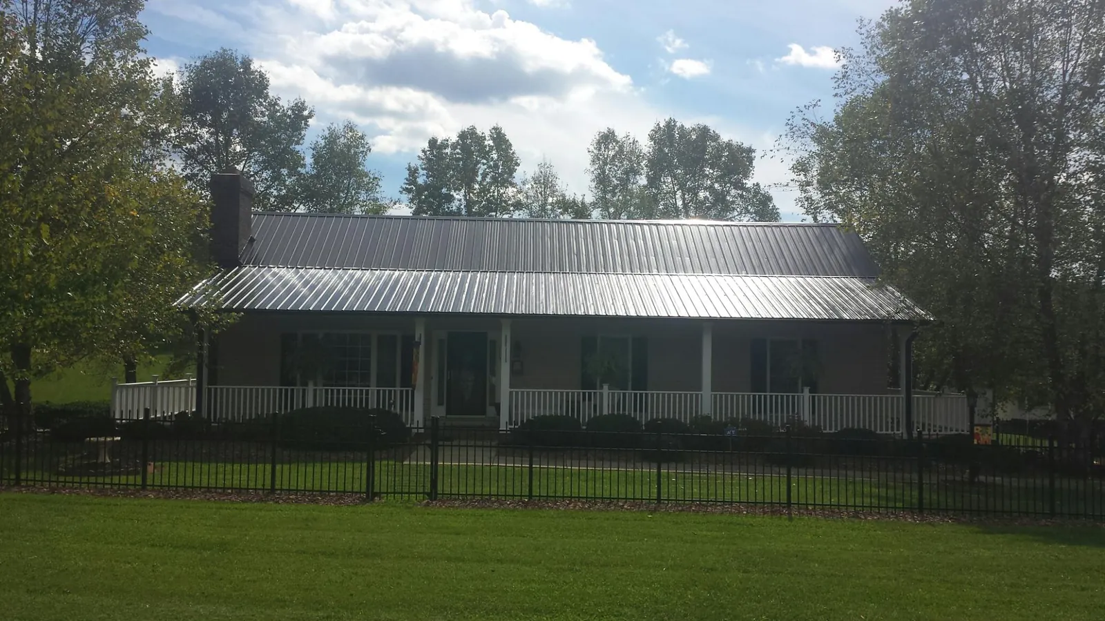 Gray metal roof on a brick ranch with a full width front porch — Gutter Guard Installation work by our crew in Salley