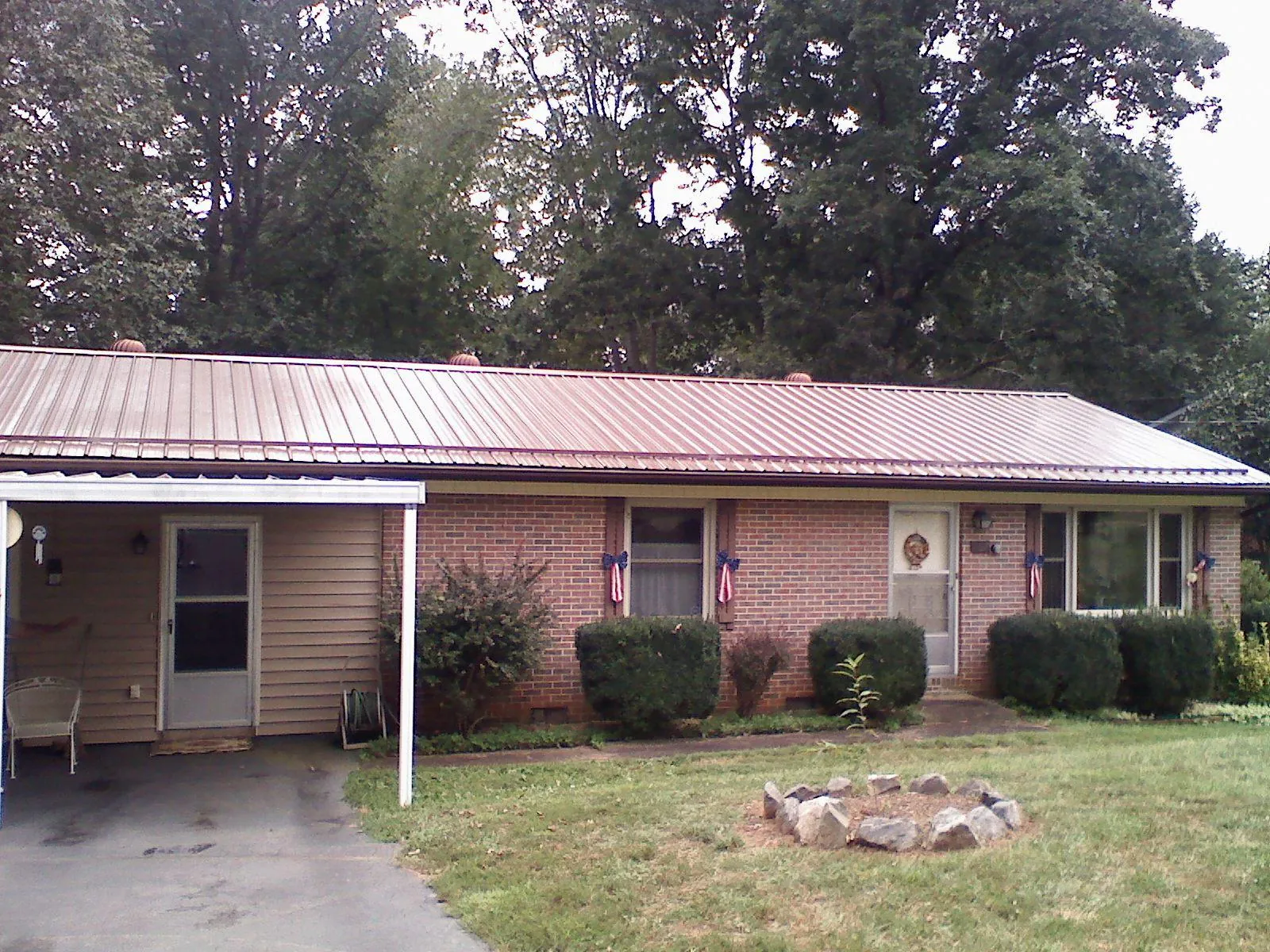 Bronze metal roof and carport on a brick ranch home — Roof Repair work by our crew in Salley